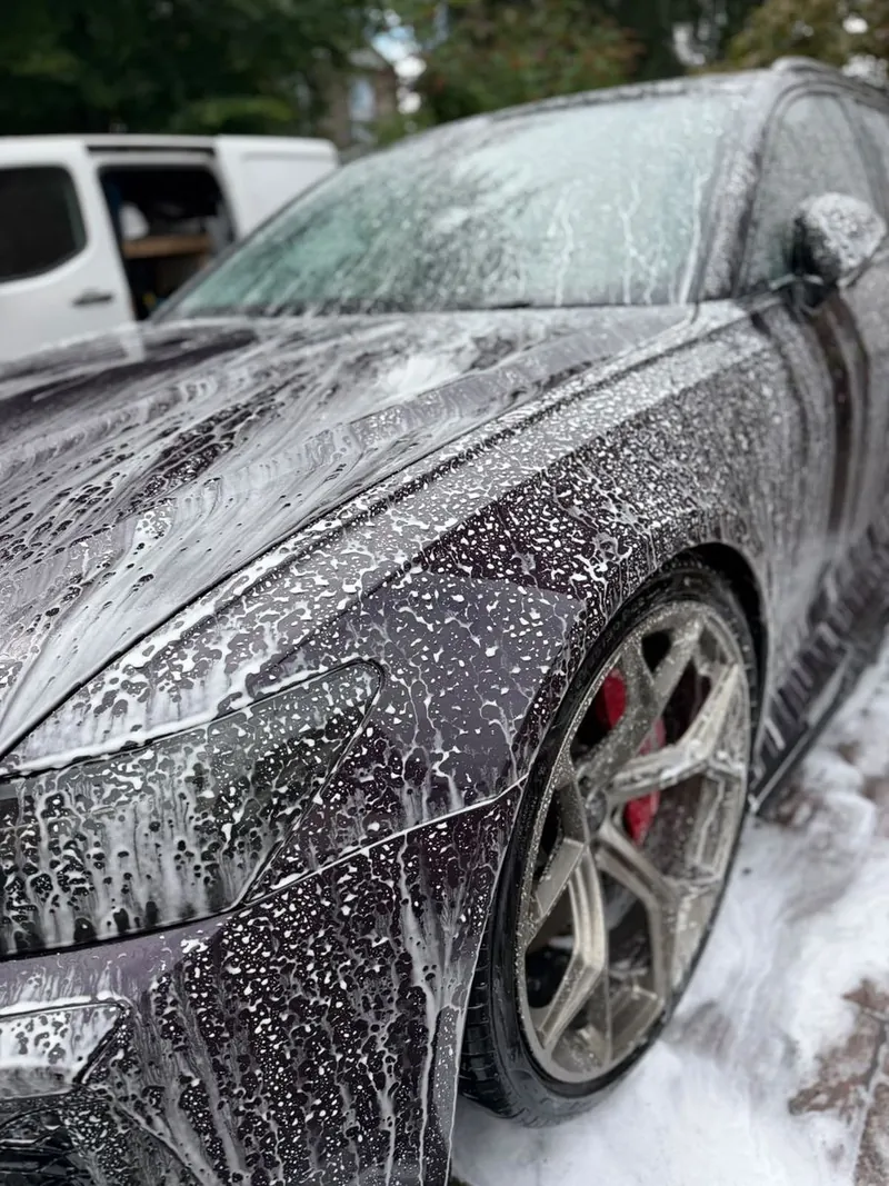 Snow foam on the front wing of an Audi RS6, with water beading on the paint
