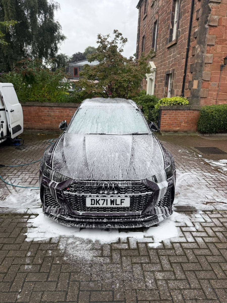 Audi RS6 Avant front end covered in snow foam during a safe wash