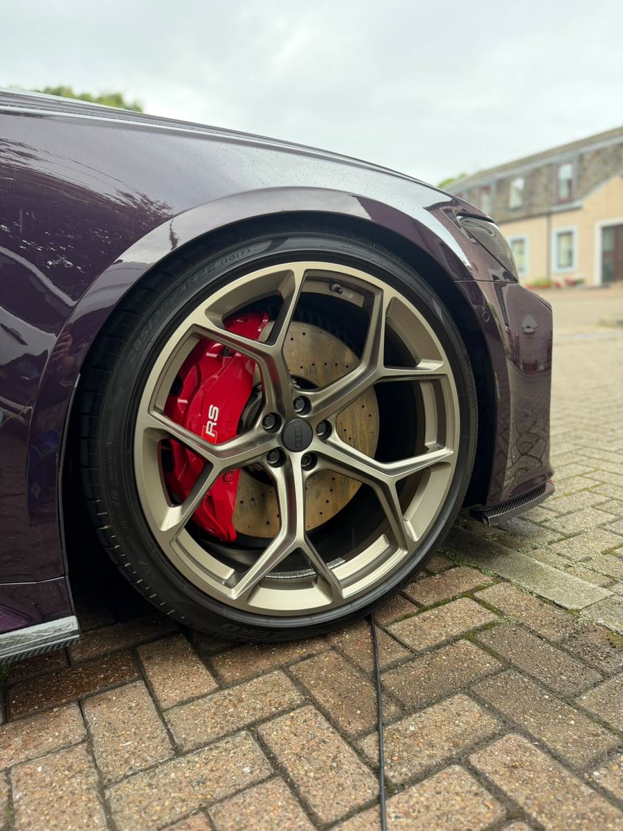 Audi RS6 bronze alloy wheel and red RS brake caliper after detailing