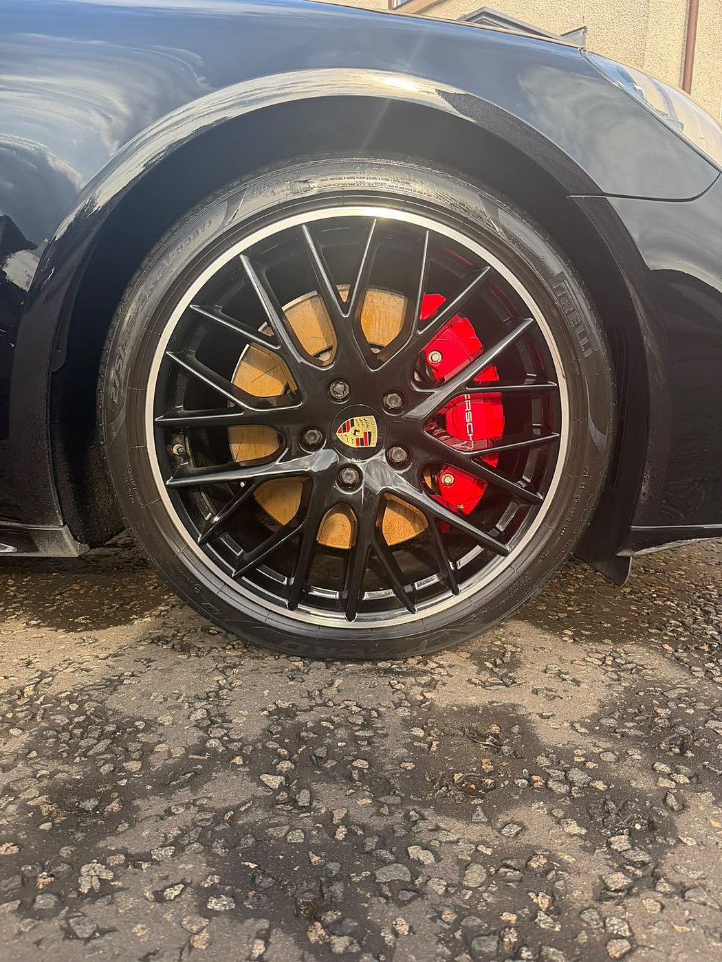 Porsche alloy wheel and red brake caliper after detailing