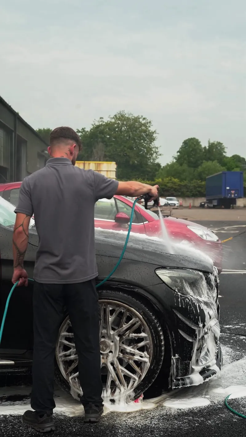 Rinse Revive applying a pH-neutral snow foam pre-wash to a car