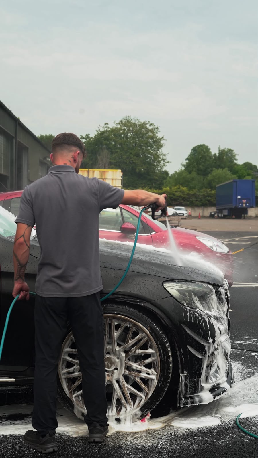 Rinse Revive applying a pH-neutral snow-foam pre-wash to a car