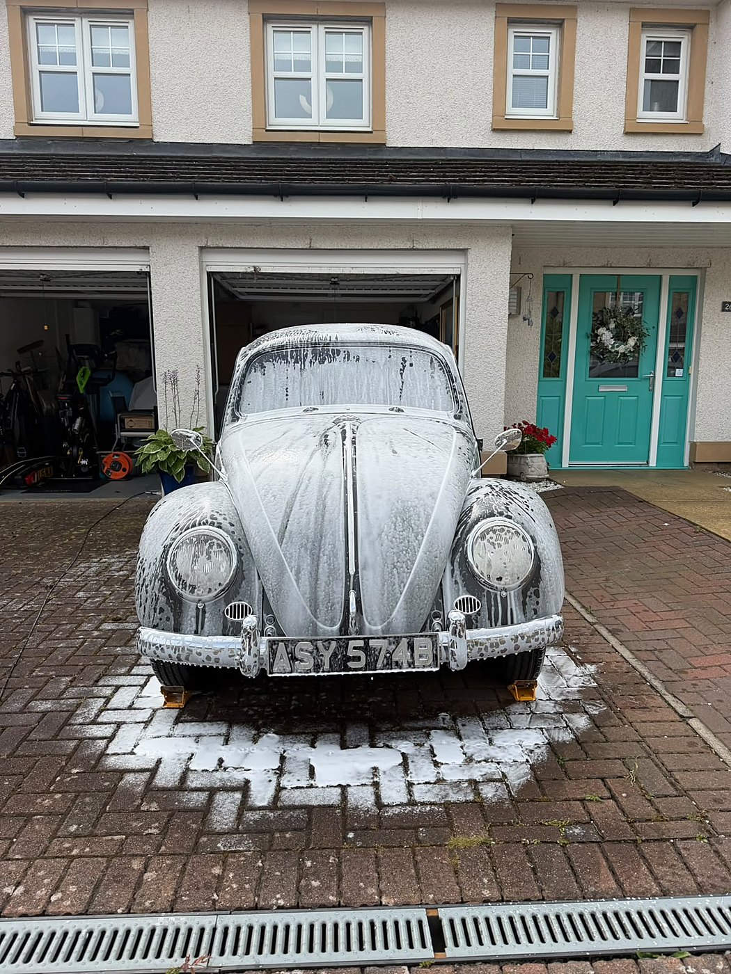 Classic VW Beetle covered in snow foam during a safe wash
