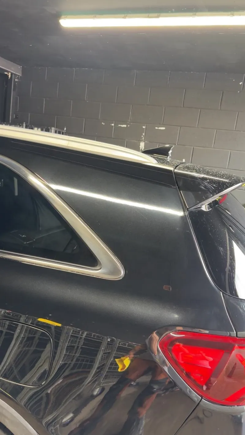 The same black panel after wet sanding and machine polishing, back to a deep gloss